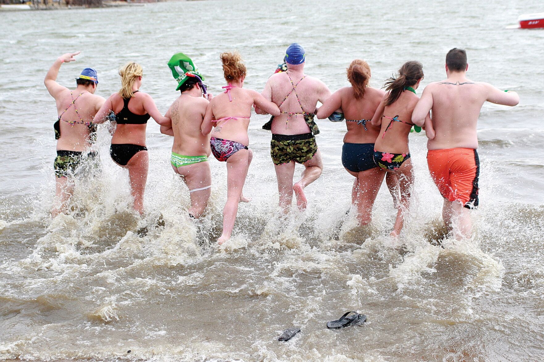 The Salty Dog team walks arm in arm through the freezing waters of Lake Manawa not just once but twice during Saturday's Polar Plunge for Special Olympics Iowa.